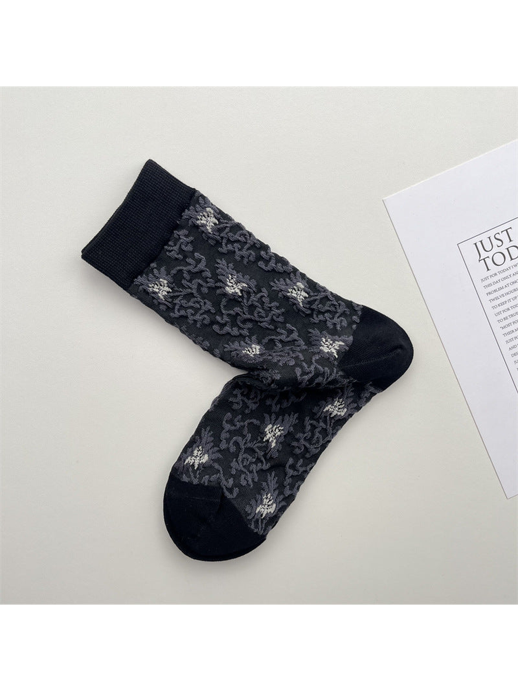 Dark gray crew socks with scattered floral pattern and black trim
