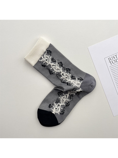 Gray crew socks with white vine side panels and contrasting cuffs