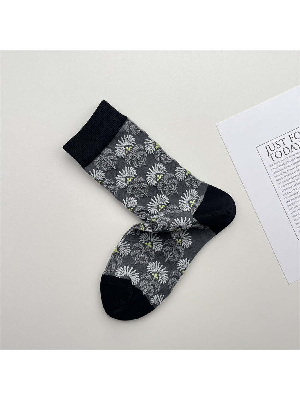 Gray crew socks with white daisy pattern and black trim