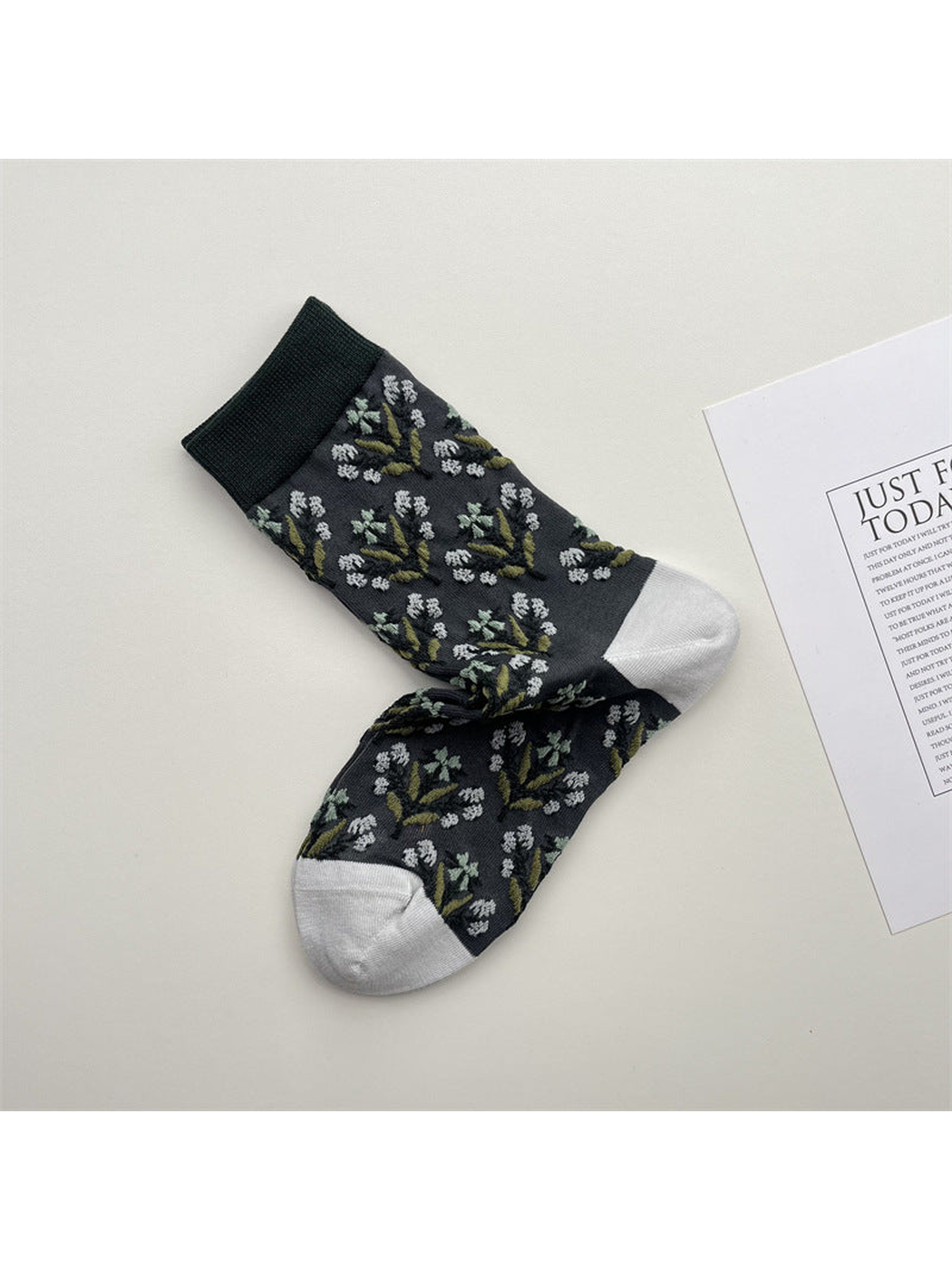 Gray crew socks with white floral sprigs and green trim