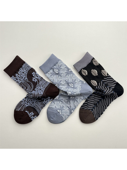 Three patterned crew sock styles arranged together on a neutral background