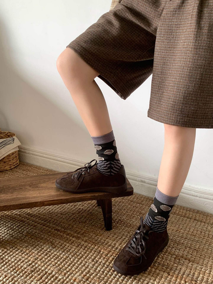 Black and gray patterned crew socks styled with brown low-top shoes