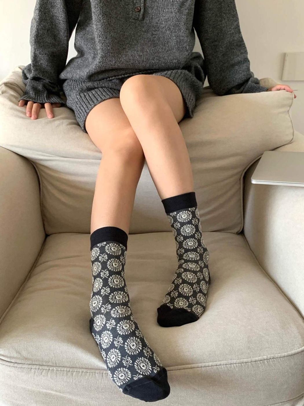 Floral medallion crew socks worn while seated on a sofa