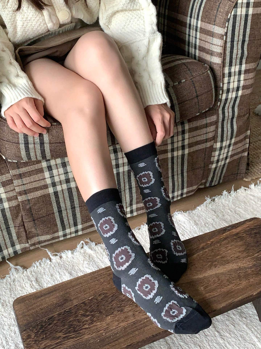 Dark gray circular-medallion crew socks in a seated close-up