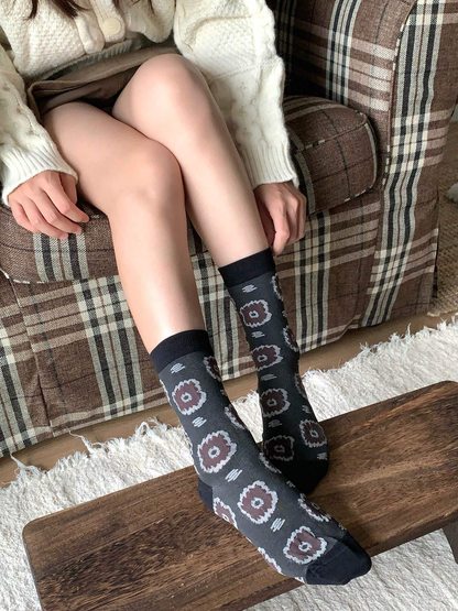 Dark gray circular-medallion crew socks in a seated close-up