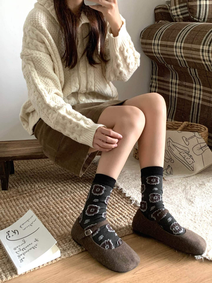 Dark gray circular-medallion crew socks styled with brown flats