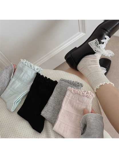 Five ruffled crew sock colors displayed with an ivory sock worn in a black shoe