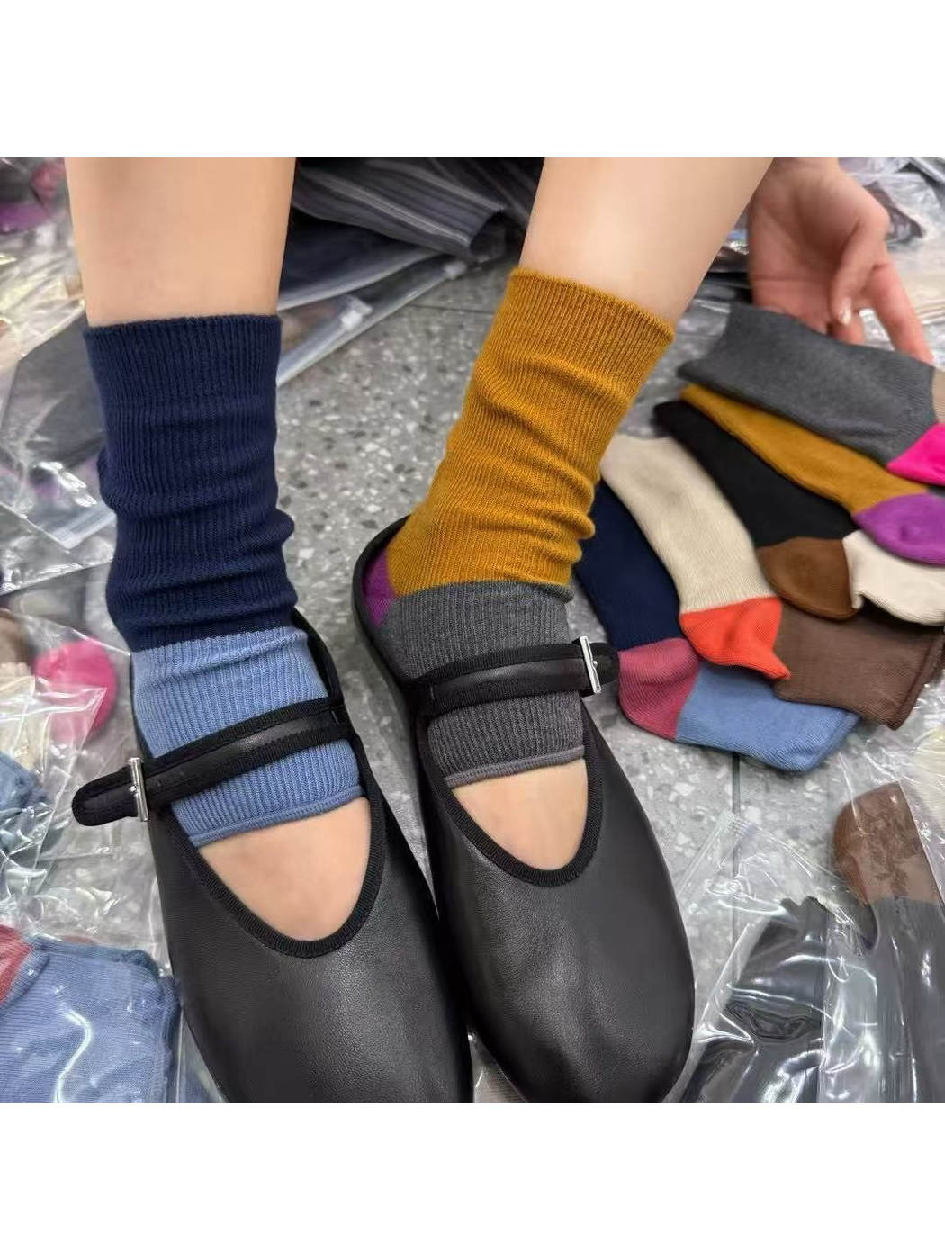 Two color-block open-toe socks styled with black Mary Jane shoes