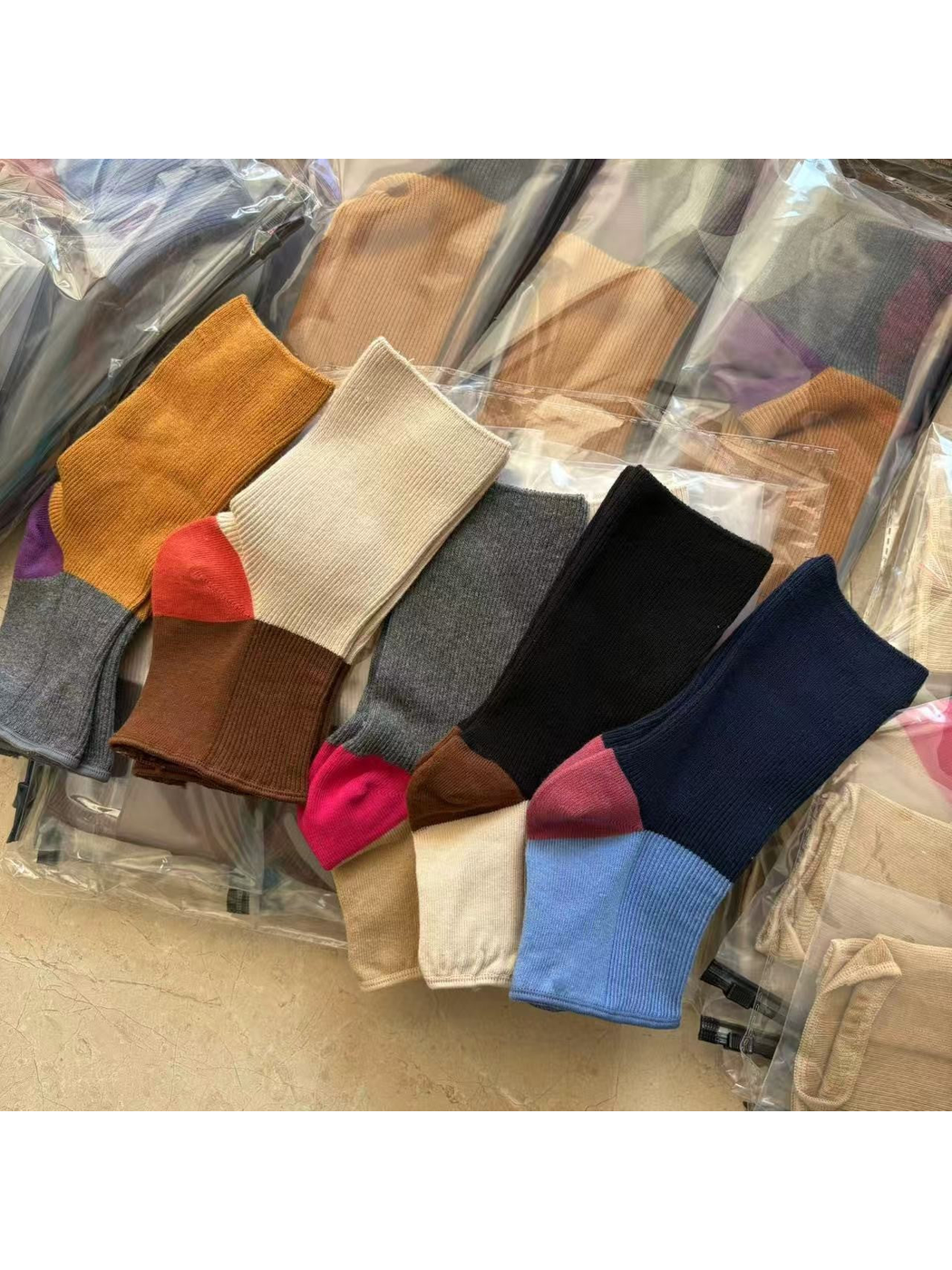 Five color-block open-toe sock designs arranged in a flat lay