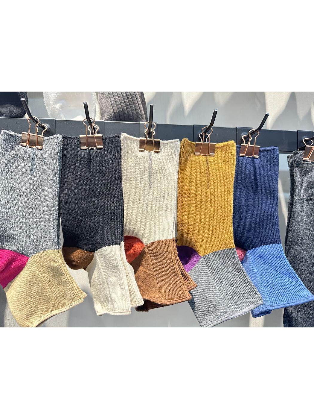 Color-block open-toe socks in several colors displayed on hanging clips