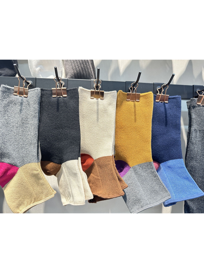 Color-block open-toe socks in several colors displayed on hanging clips