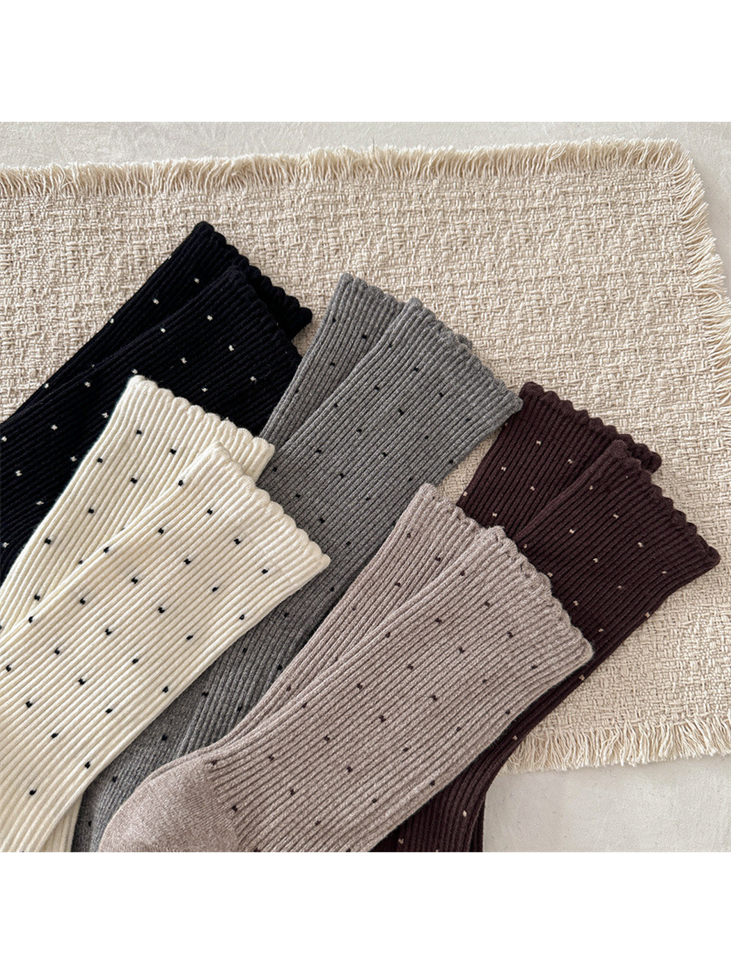 Close-up of scalloped cuffs, vertical ribbing and contrasting dots