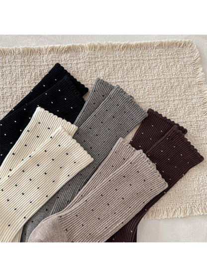 Close-up of scalloped cuffs, vertical ribbing and contrasting dots