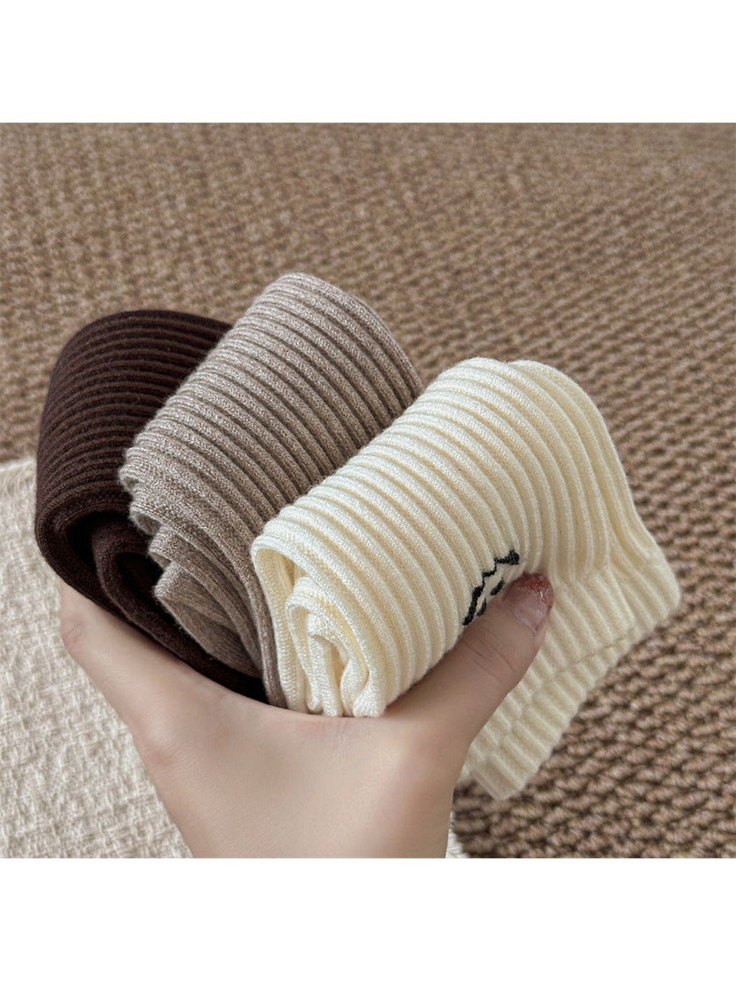 Folded brown, greige and ivory ribbed socks showing the flexible shaft construction