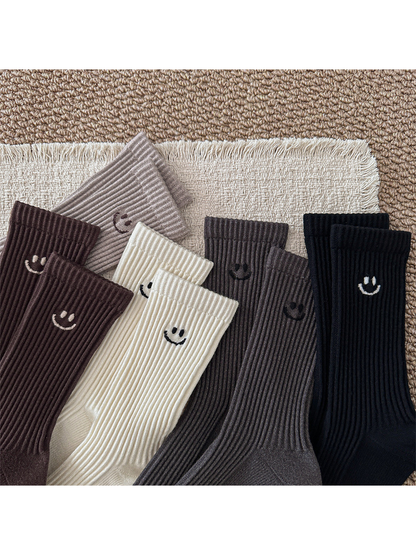 Close-up of contrasting smiley motifs on the five ribbed sock colors