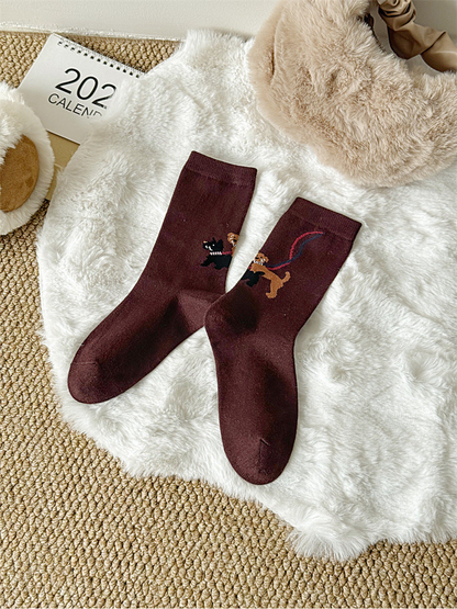 Burgundy crew socks with dog-walking motif, full pair view