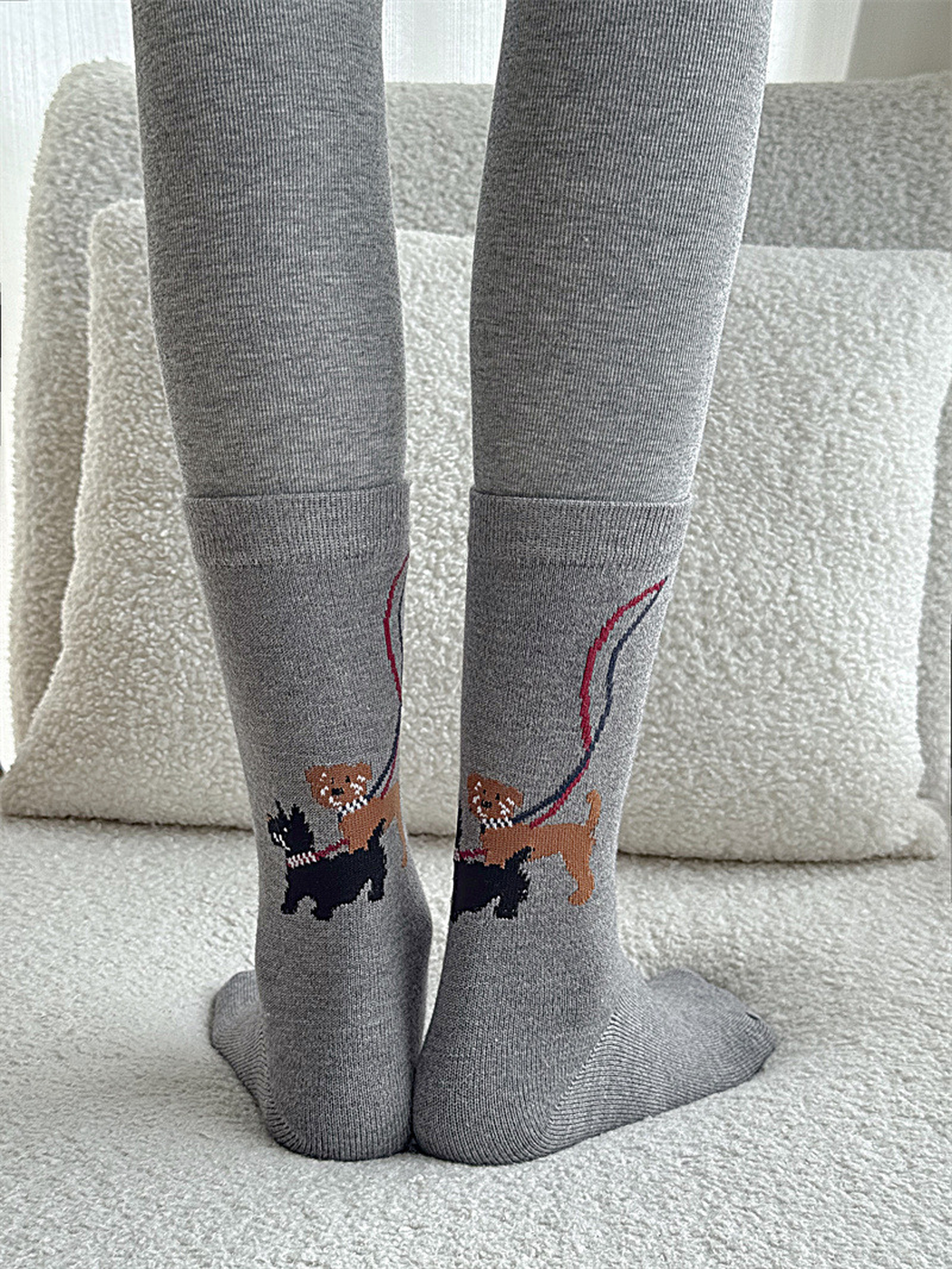 Gray dog-walking motif crew socks worn from the rear