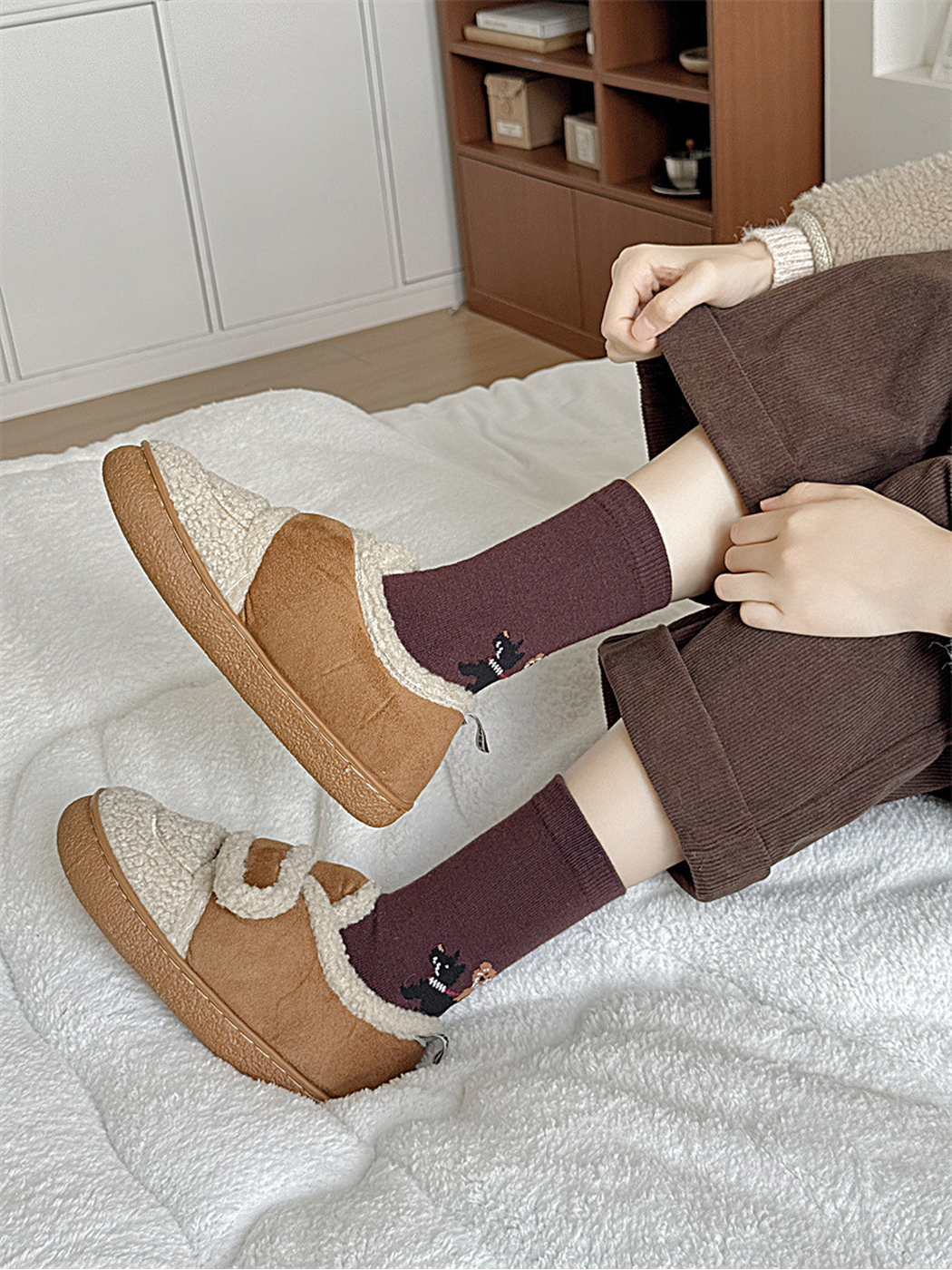Burgundy dog-motif crew socks worn with lined slippers