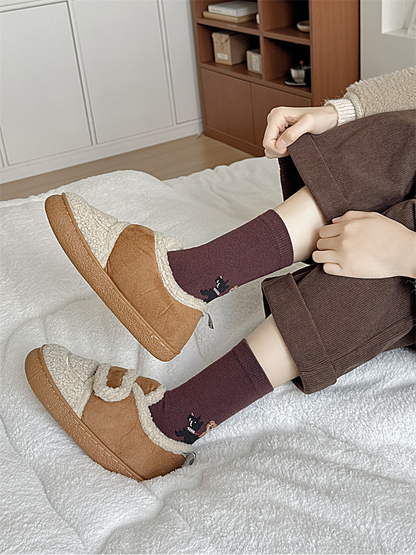 Burgundy dog-motif crew socks worn with lined slippers