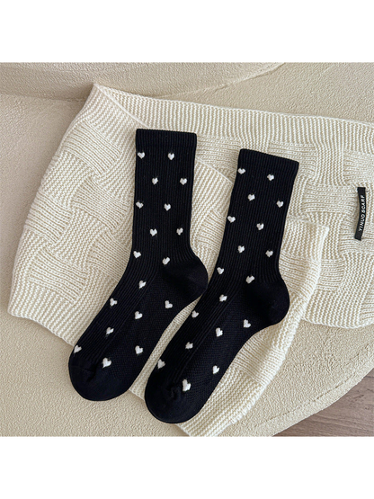 Black heart-pattern crew socks displayed as a pair