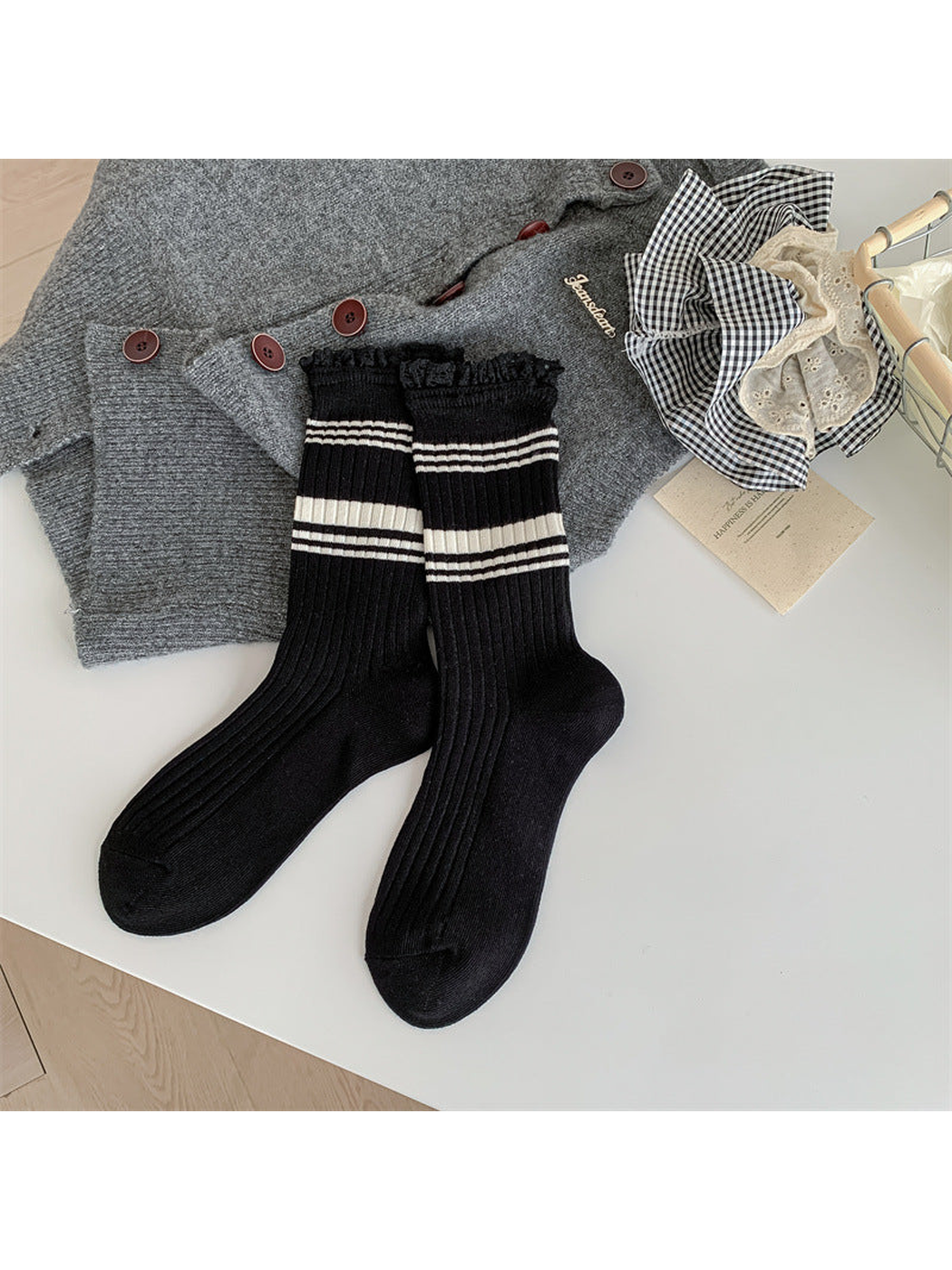 Black ribbed crew socks with cream stripes and black lace-trimmed cuffs