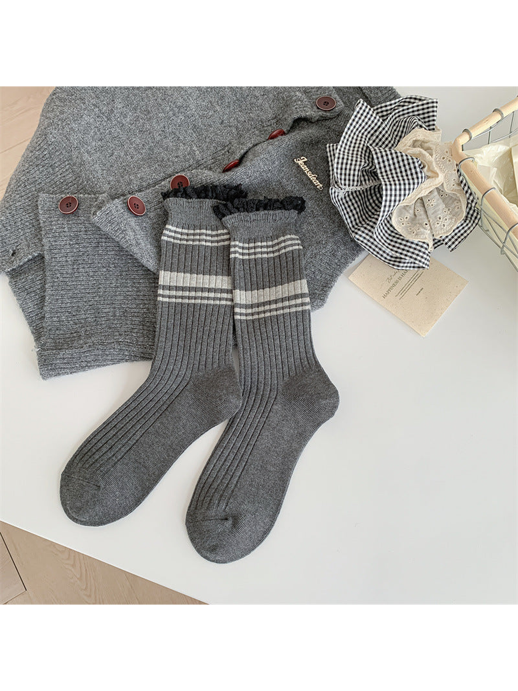 Dark gray ribbed crew socks with light gray stripes and black lace-trimmed cuffs