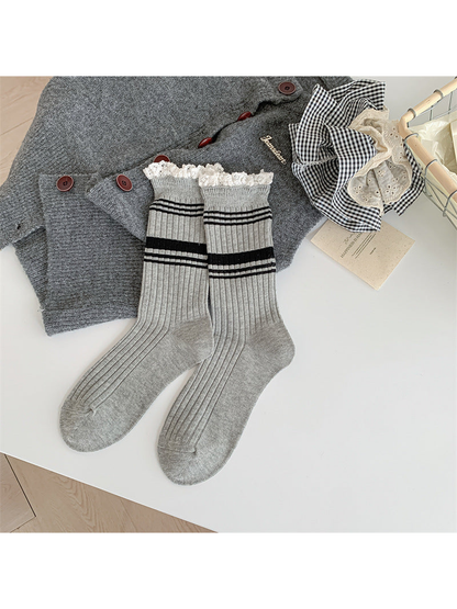 Light gray ribbed crew socks with black stripes and white lace-trimmed cuffs