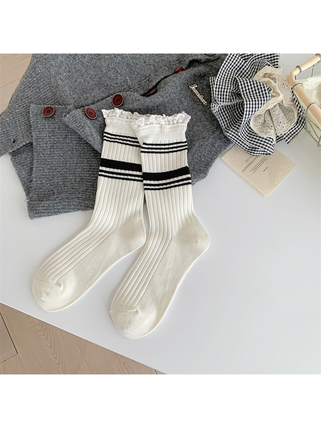 White ribbed crew socks with black stripes and white lace-trimmed cuffs