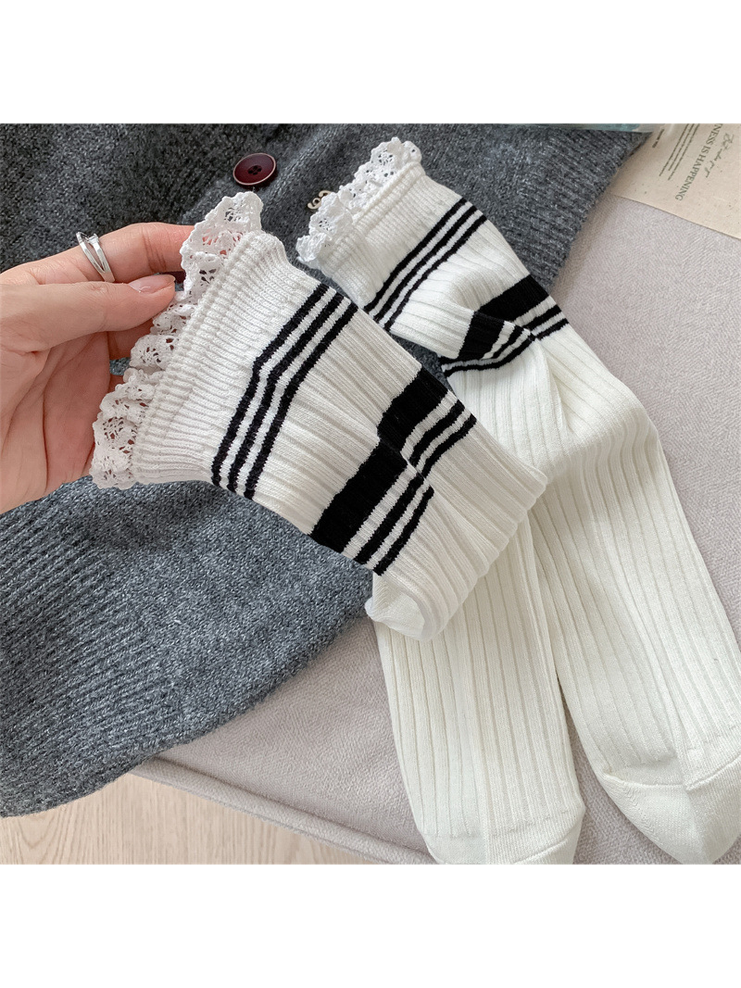Close-up of white ribbed socks with black stripes and scalloped lace cuffs
