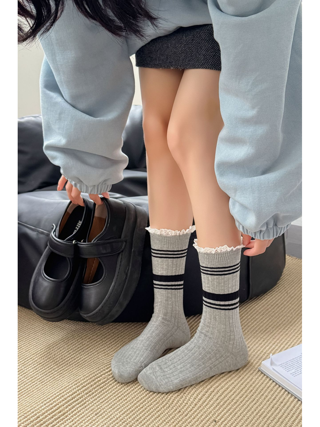Light gray ribbed crew socks worn with striped lace cuffs fully visible