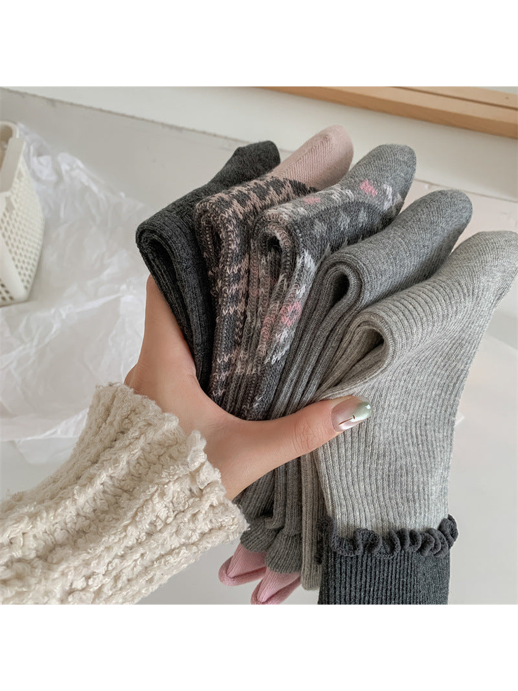 Close-up of five folded gray sock styles with ribbed and patterned finishes