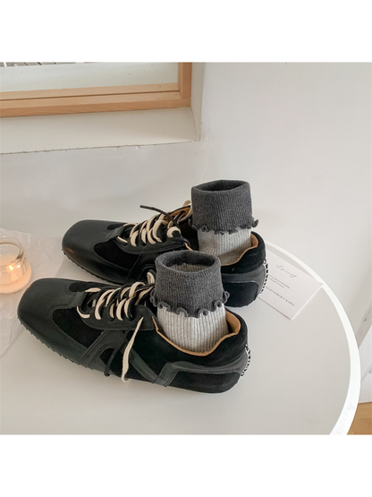Light gray ribbed socks with dark folded ruffle cuffs styled with black sneakers