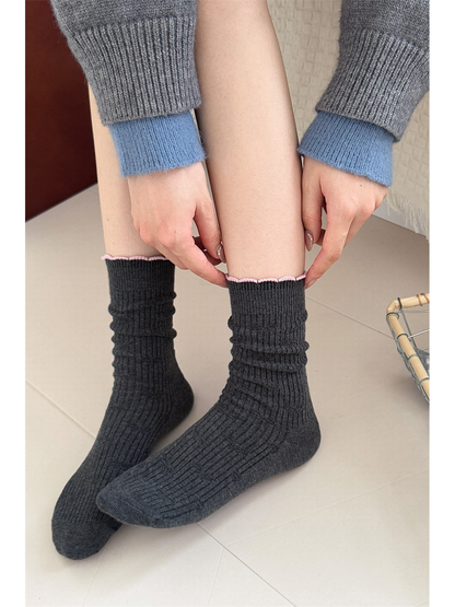 Dark gray ribbed crew socks worn scrunched at the ankles