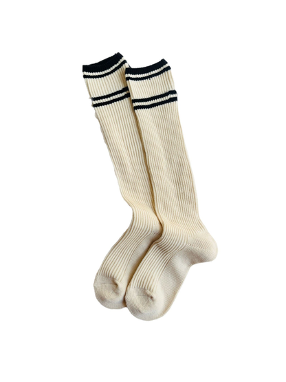 Ivory ribbed knee-high socks with black stripes on a white background