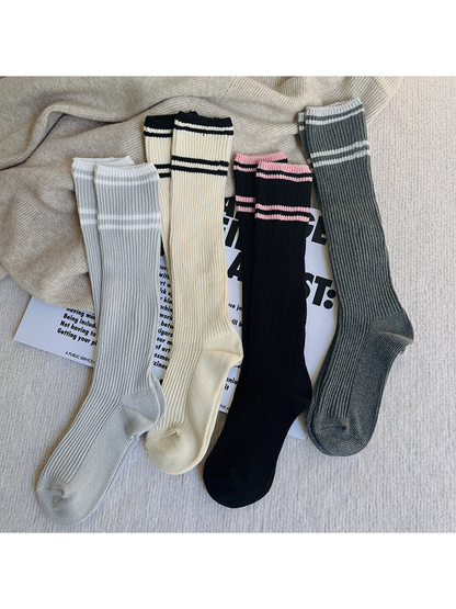 Ivory, black, dark gray and light gray striped knee-high socks displayed together