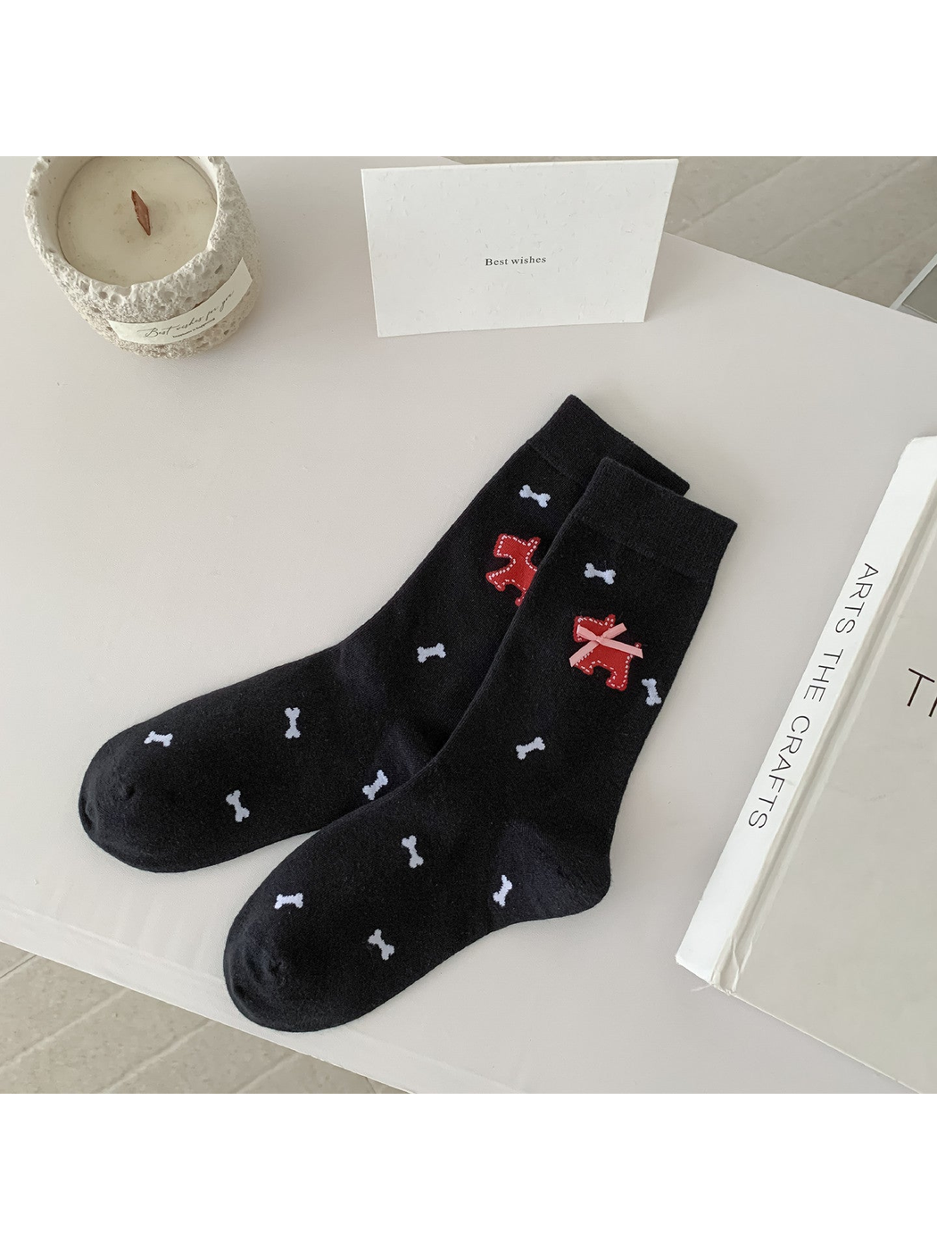 Black crew socks with white bone motifs and a red dog applique