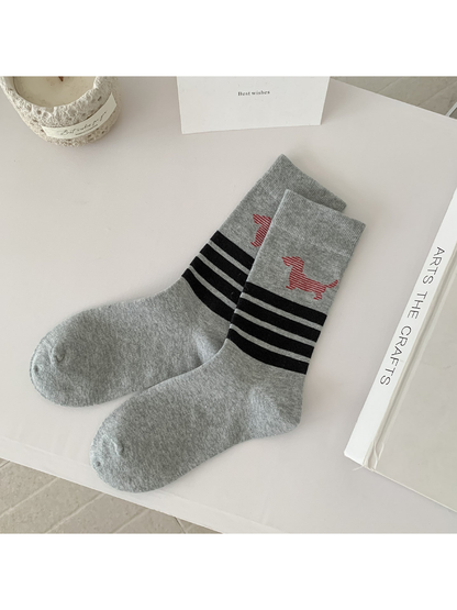 Light gray crew socks with black stripes and a red striped dog motif