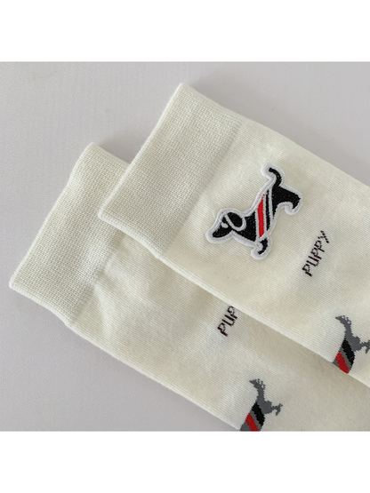 Close-up of the ivory sock's ribbed cuff and raised striped dog patch