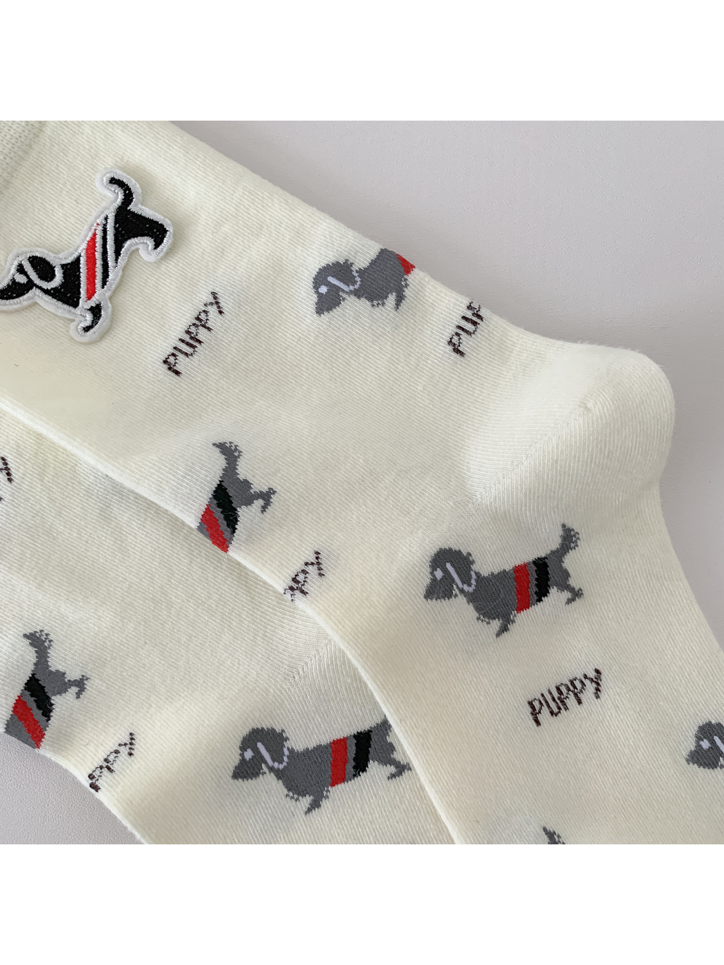 Close-up of the dog and lettering pattern across the ivory socks