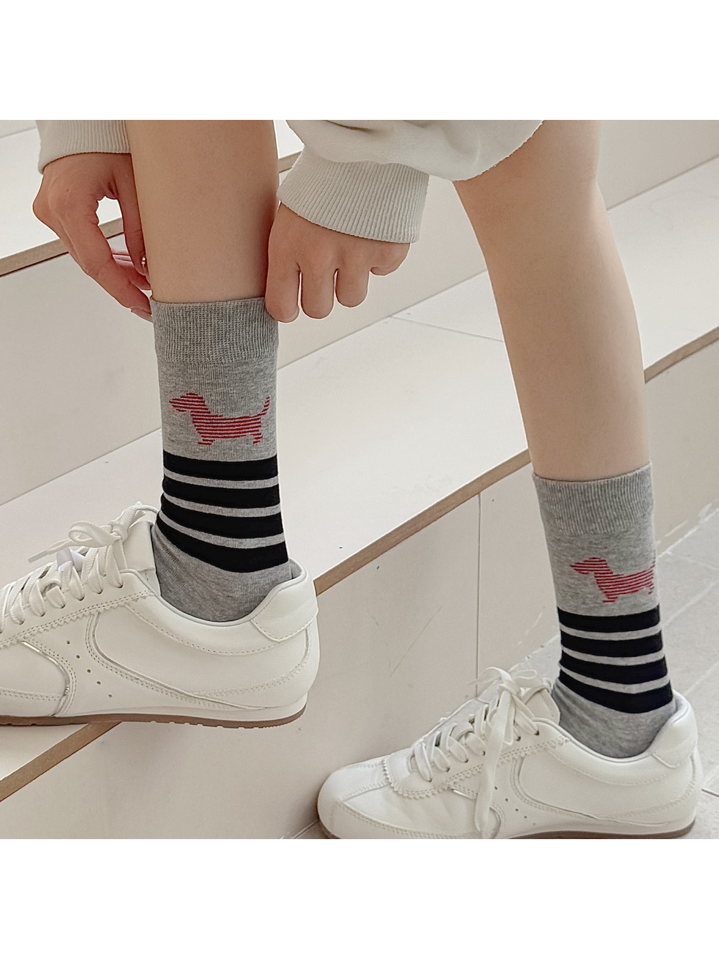 Light gray striped dog crew socks worn with white low-top sneakers