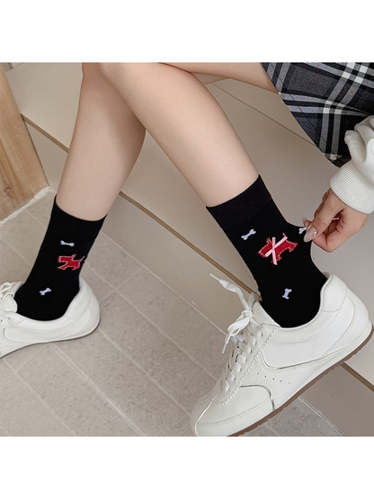 Black dog-and-bone crew socks worn with white low-top sneakers