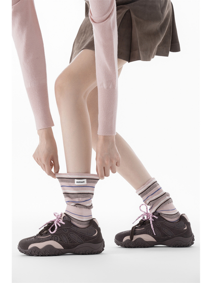 Light pink striped socks styled with dark sneakers