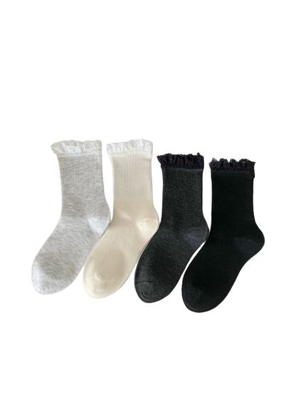 Ivory, light gray, dark gray and black lace-trim crew socks on a white background