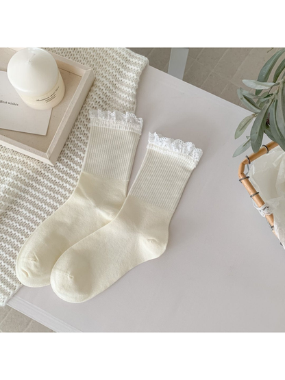 Ivory crew socks with white lace-trim cuffs, full pair view