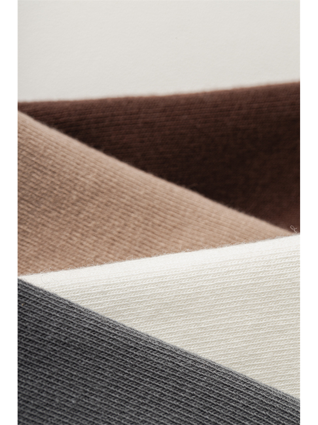 Close-up of fine knit and ribbed textures in four sock colors