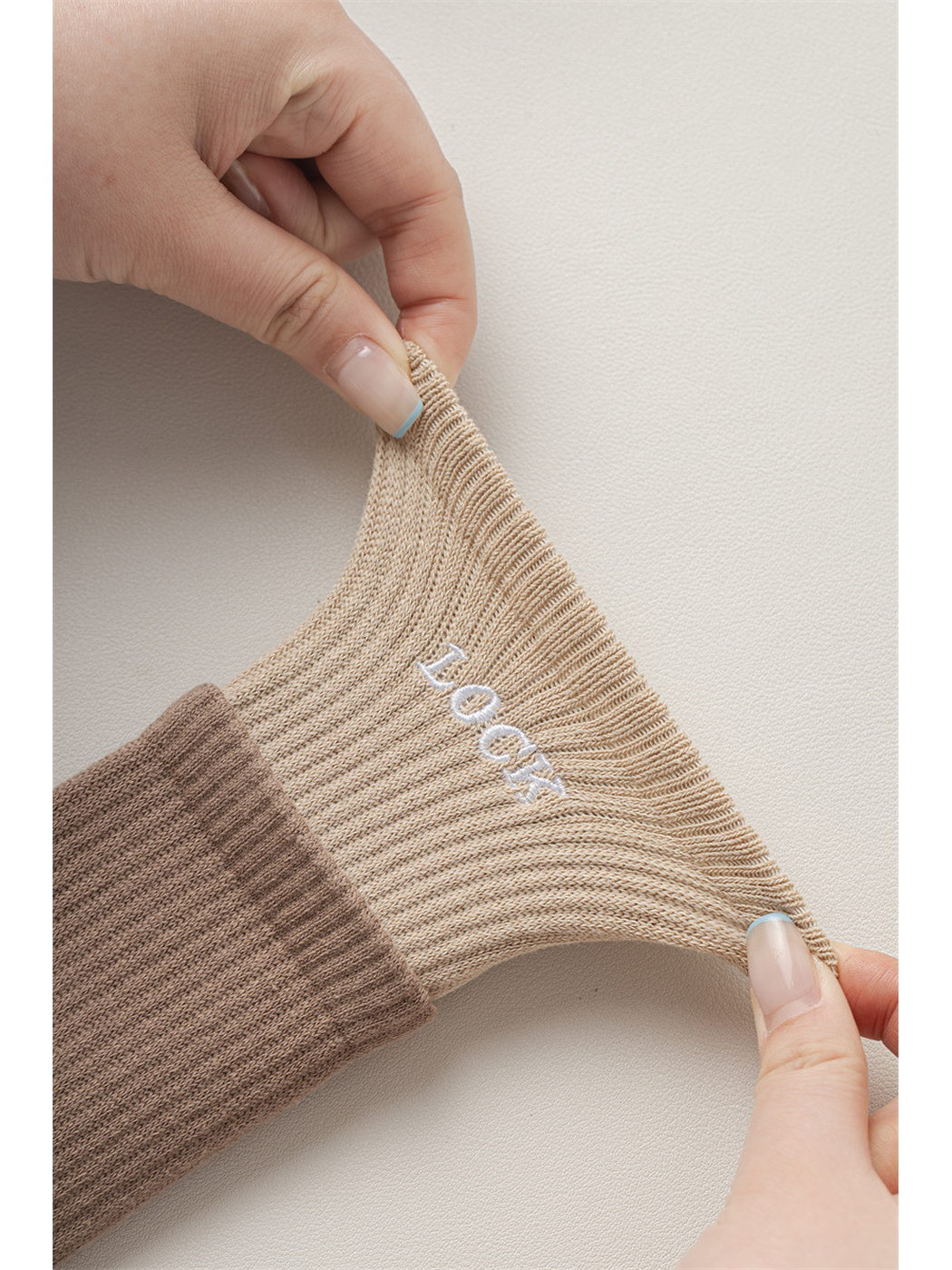 Close-up of hands stretching the contrasting ribbed sock cuff