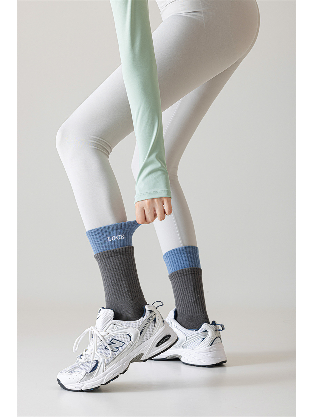 Dark gray and light blue crew socks styled above white sneakers