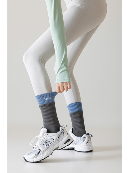Dark gray and light blue crew socks styled above white sneakers