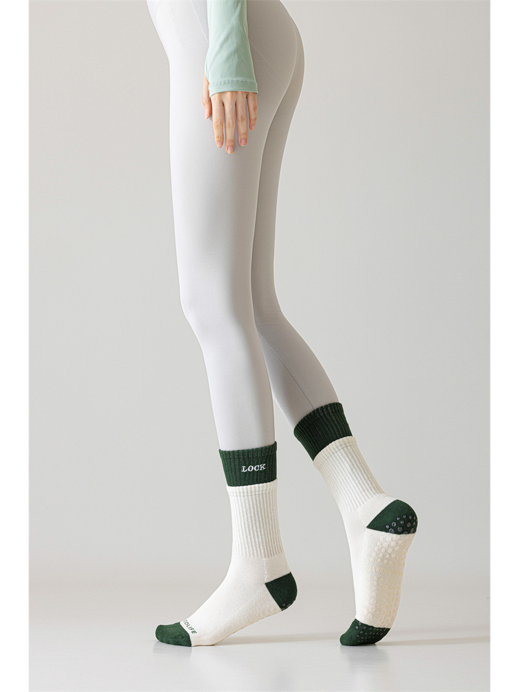Ivory and dark green crew socks worn with one sole raised