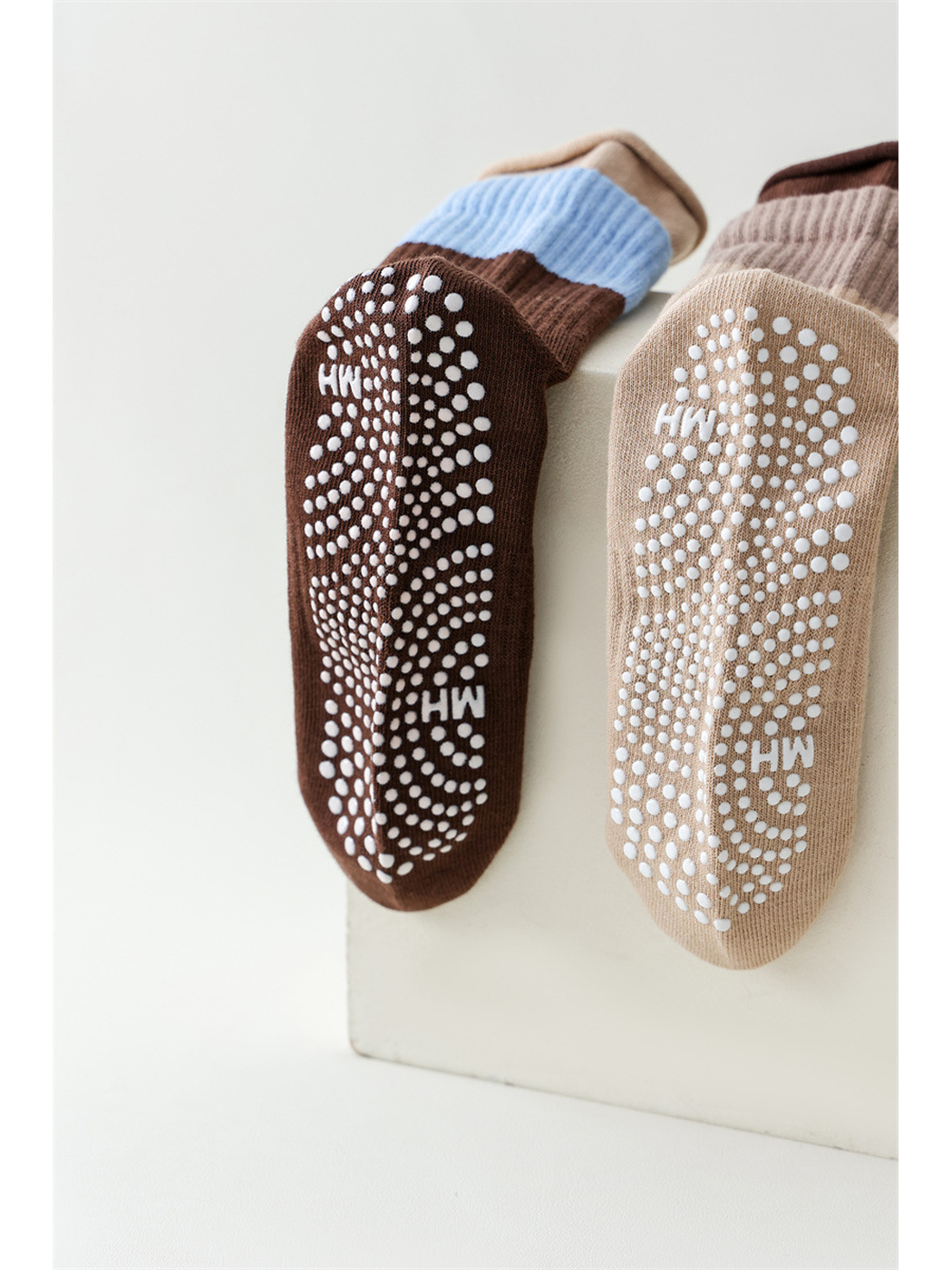 Brown and khaki sock soles with curved rows of raised white dots
